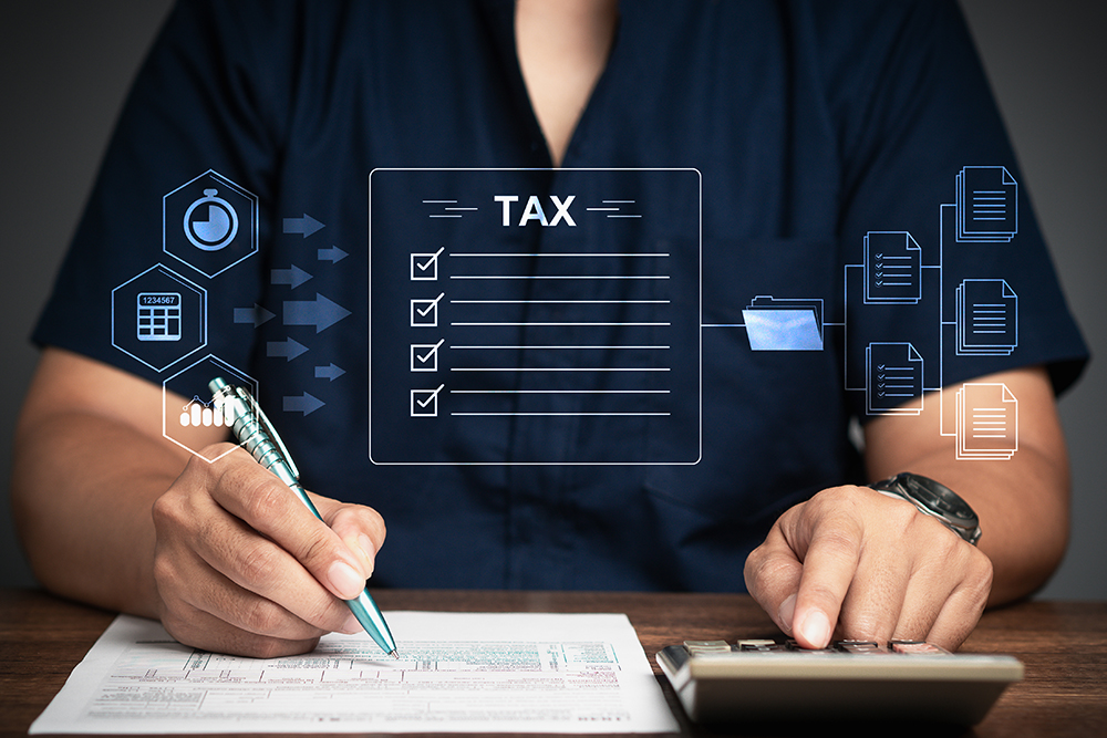 A Businessman using a calculator to calculate tax while sitting at the table