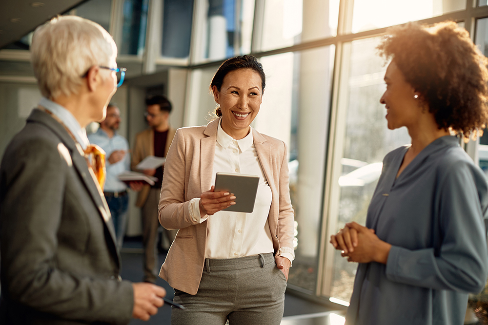 Businesswoman communicating with female colleagues while using digital tablet during the meeting